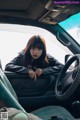 A woman sitting in the driver's seat of a car.