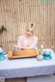 A woman sitting at a table with a tray of tea.