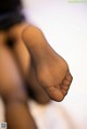 A close up of a woman's foot in black stockings.