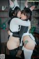 A couple of women in bunny ears hugging each other.