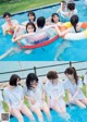 A group of young women sitting in a swimming pool.