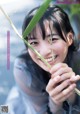 A young woman holding a plant in her hand.