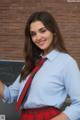 A woman in a school uniform posing in front of a blackboard.