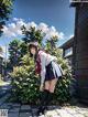 A girl in a school uniform standing in front of a building.