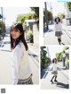 A young woman in a school uniform is walking down the street.