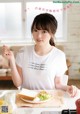 A woman sitting at a table with a plate of food.