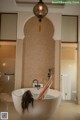 A woman laying in a bathtub in a bathroom.