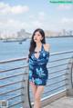 A woman in a blue dress standing on a pier.