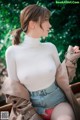 a woman in a white top and denim shorts sitting on a bench