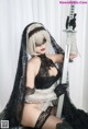 A woman in a black and white outfit holding a sword.