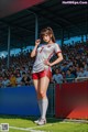 A woman standing on a soccer field in front of a crowd.